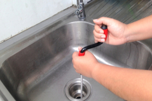 Using a plumber's snake to unclog a bathroom sink drain